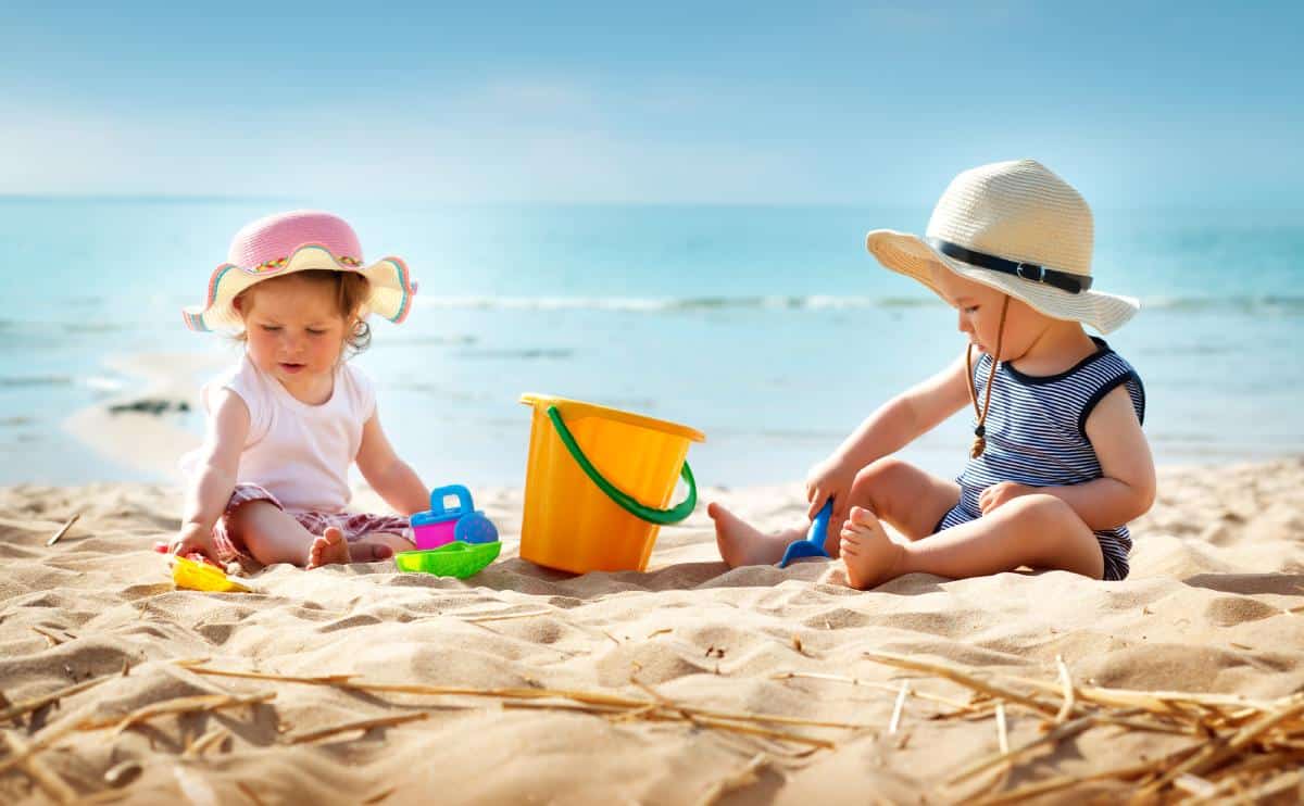 babygirl and babyboy sitting on the beach